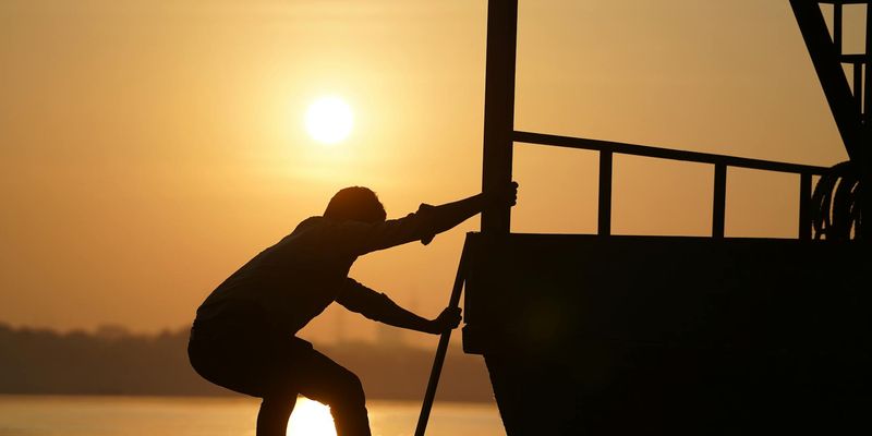 Silhouette of a person balancing during sunrise.